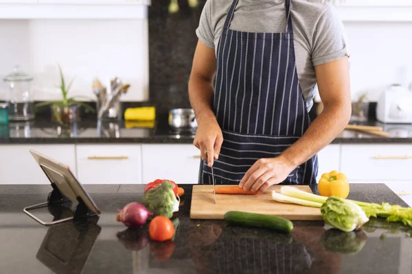 Ένας Άντρας Στην Κουζίνα Φοράει Ποδιά Και Κόβει Λαχανικά Διαμονή — Φωτογραφία Αρχείου