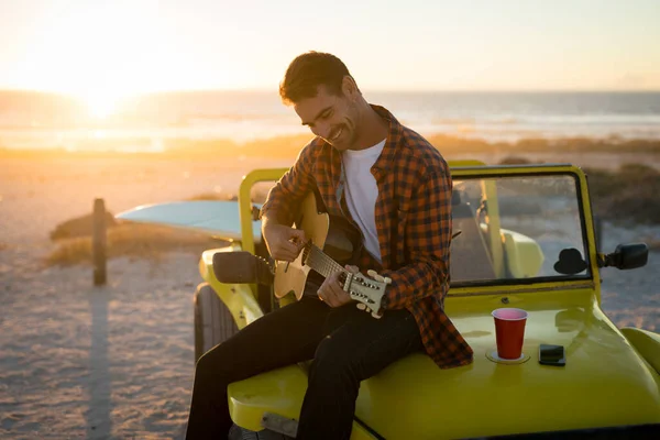 Hombre Caucásico Feliz Sentado Buggy Playa Junto Mar Tocando Guitarra — Foto de Stock