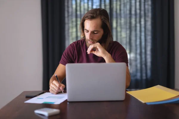 Hombre Caucásico Sentado Mesa Trabajando Desde Casa Tomando Notas Usando — Foto de Stock