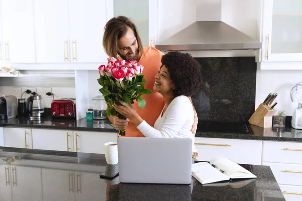 Feliz Pareja Diversa Sentada Cocina Hombre Que Flores Permanecer Casa — Foto de Stock