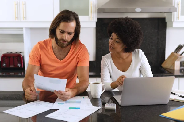 Vielfältiges Paar Das Mit Laptop Der Küche Sitzt Und Rechnungen — Stockfoto