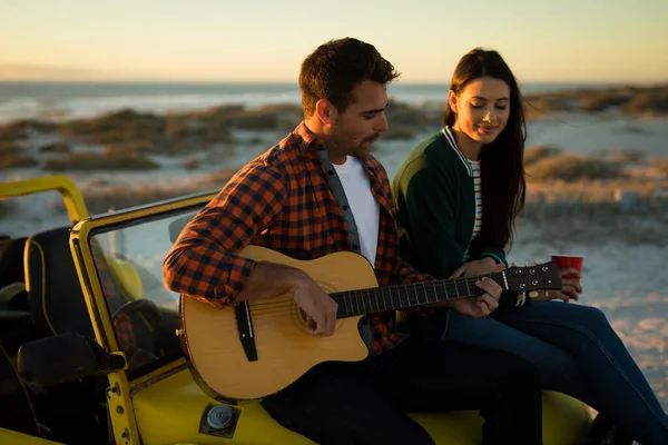 Happy Caucasian Couple Sitting Beach Buggy Sea Playing Guitar Drinking — Stock Photo, Image