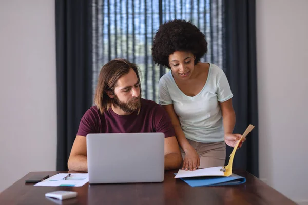 Coppia Diversificata Tavolo Che Lavora Casa Usando Laptop Controllando Documenti — Foto Stock