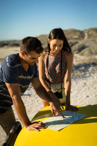 海によるビーチバギーのロードマップを読んで幸せな原因アジアのカップル 夏休みのロードトリップでビーチブレイク — ストック写真