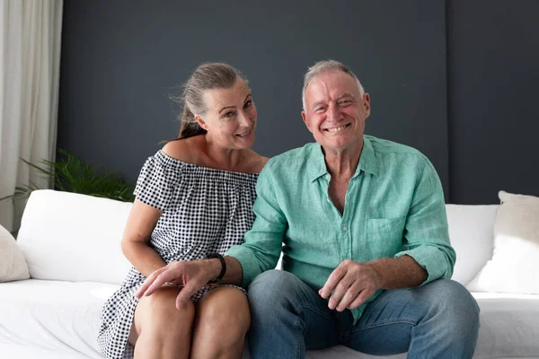 リビングルームで幸せな白人の高齢者のカップルは ソファの上でビデオ通話 話して笑顔を作る 隔離されたまま家にいると — ストック写真