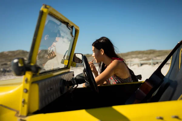 Happy Caucasian Woman Leaning Beach Buggy Putting Lipstick Beach Break — Stock Photo, Image