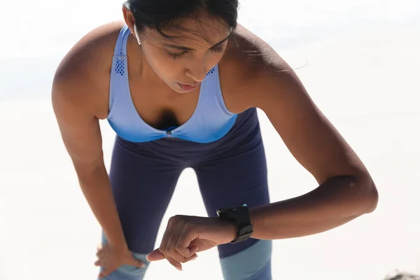 混合赛女子在海滩上锻炼 检查身体是否聪明 海上健康的户外闲暇时间 — 图库照片