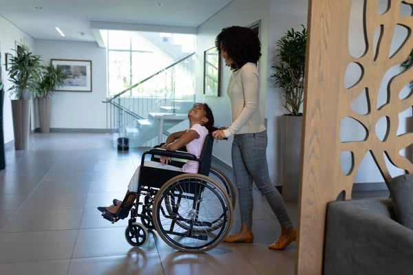 Feliz Madre Mestiza Empujando Hija Sonriente Silla Ruedas Través Del —  Fotos de Stock