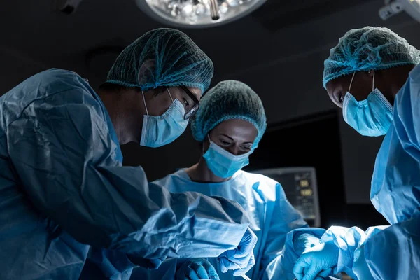手術を行うフェイスマスクを着用した手術室での男性と女性の外科医の多様なグループ コロナウイルスにおける医療 医療サービス Covid 19パンデミック — ストック写真