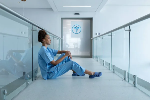 Médica Afro Americana Sentada Corredor Hospital Olhar Para Frente Serviços — Fotografia de Stock