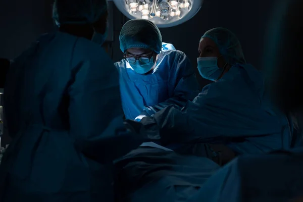 Ameliyathanede Yüz Maskesi Takıp Ameliyat Yapan Çeşitli Erkek Kadın Cerrahlar — Stok fotoğraf