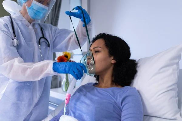 Vit Kvinnlig Doktor Ppe Dräkt Som Sätter Respirator Afrikansk Amerikansk — Stockfoto