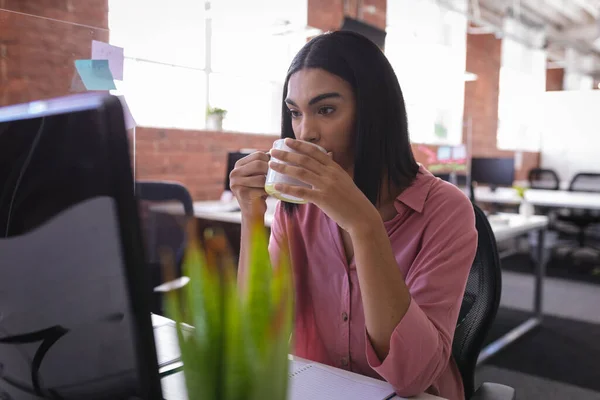 Blandad Ras Affärskvinna Sitter Kontoret Framför Datorn Och Dricker Kaffe — Stockfoto