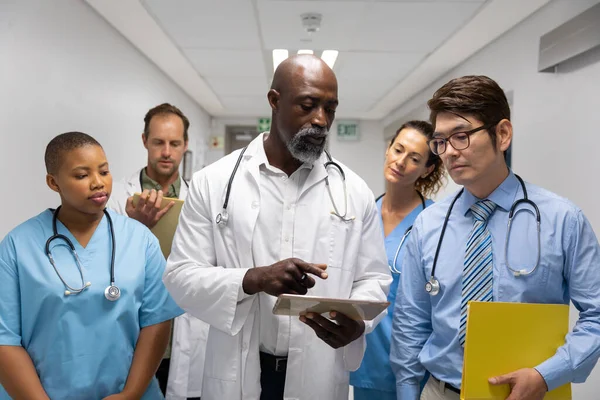 Bir Grup Erkek Kadın Doktor Tablete Bakarak Koridorda Yürüyorlar Ilaç — Stok fotoğraf