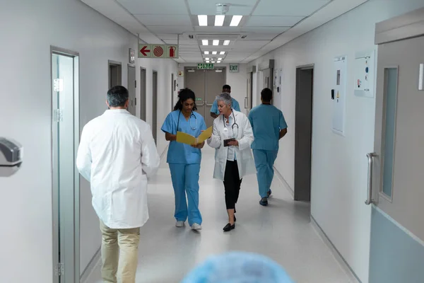 Různí Lékaři Mužského Ženského Pohlaví Procházejí Nemocniční Chodbou Diskutují Lékařské — Stock fotografie