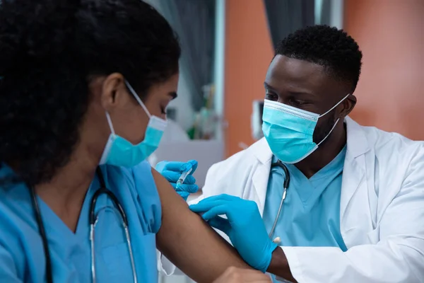 顔のマスクを着ている医師の混合レースのカップルは注射を作る コロナウイルスにおける医療 医療サービス Covid 19パンデミック — ストック写真