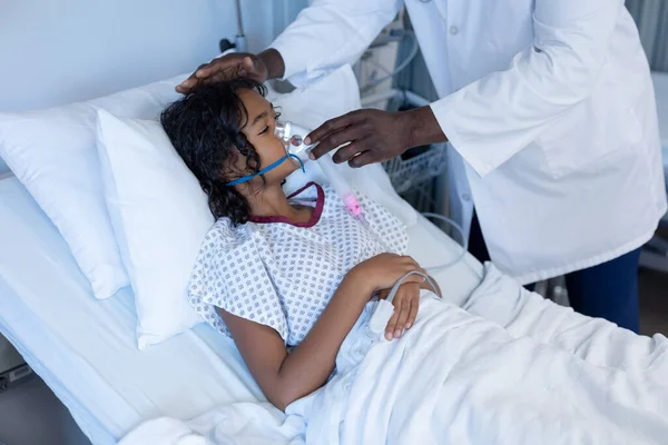 男医生把氧气面罩通风机放在生病的混血女病人的病床上 Coronavirus Covid大流行病期间的医疗 保健和保健服务 — 图库照片