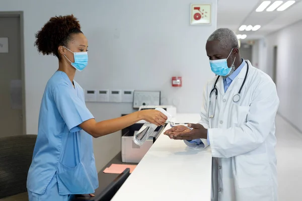 Diverse Mannelijke Vrouwelijke Artsen Met Gezichtsmaskers Desinfecteren Handen Toonbank Het — Stockfoto