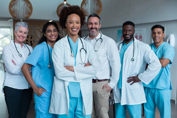 成群结队站在医院走廊里的男医生和女医生对着镜头微笑的画像 保健和保健服务 — 图库照片