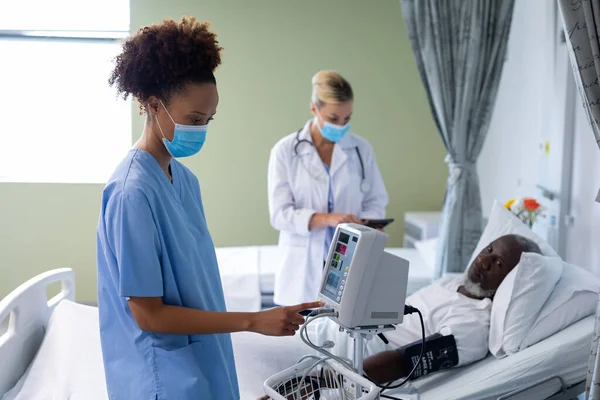 Médica Raça Mista Usando Máscara Facial Usando Monitor Pressão Arterial — Fotografia de Stock