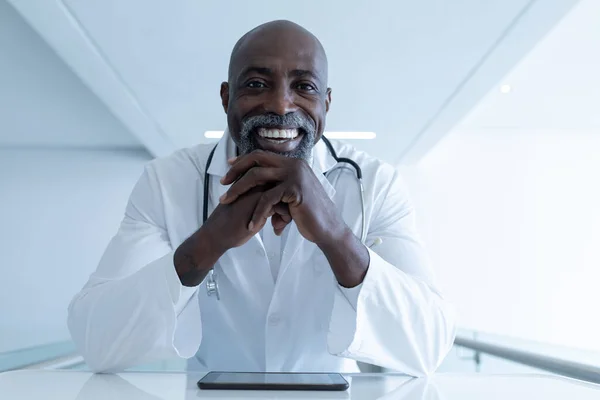 Sonriendo Afroamericano Médico Masculino Sentado Escritorio Con Tableta Que Consulta — Foto de Stock