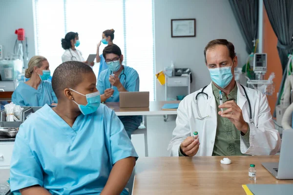 Kafkasyalı Maskeli Erkek Doktor Kadın Meslektaşı Için Kovid Aşısı Hazırlıyor — Stok fotoğraf