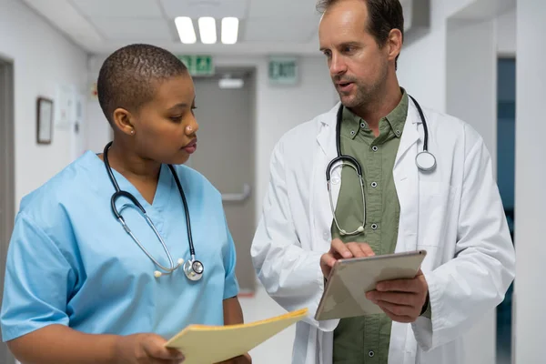 Couple Diverse Male Female Doctors Walking Corridor Looking Tablet Medicine — Stock Photo, Image