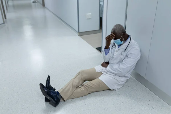 Médico Afro Americano Vestindo Máscara Sentado Chão Corredor Hospital Preocupante — Fotografia de Stock