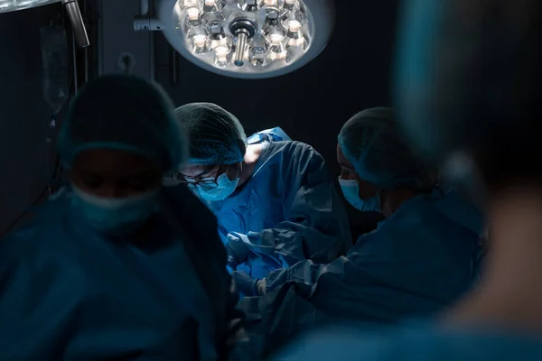 Różnorodna Grupa Chirurgów Męskich Żeńskich Sali Operacyjnej Maskach Twarzy Wykonujących — Zdjęcie stockowe
