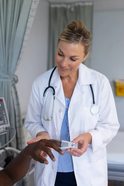 白人女医生在男性病人的手指上贴上脉动血氧计 保健和保健服务 — 图库照片