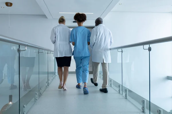 Three Diverse Male Female Doctors Walking Hospital Corridor Talking Medicine — Stock Photo, Image