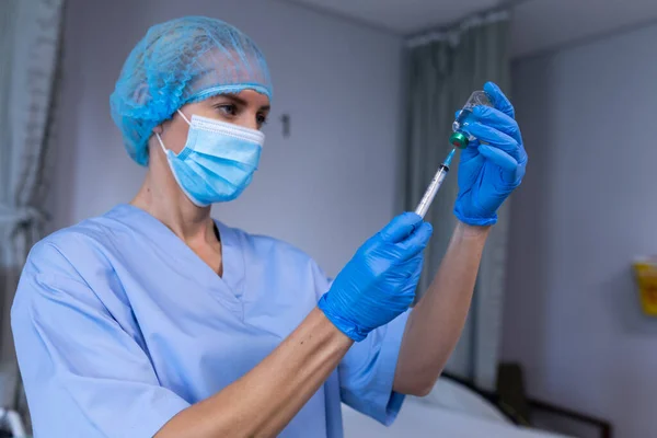 注射器を保持し 予防接種を準備顔マスクを身に着けて病院で白人女性医師 コロナウイルス感染症の治療に従事する医療従事者は — ストック写真