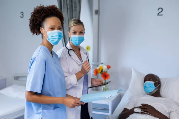 Retrato Dos Doctoras Diversas Con Máscaras Faciales Pie Junto Paciente — Foto de Stock