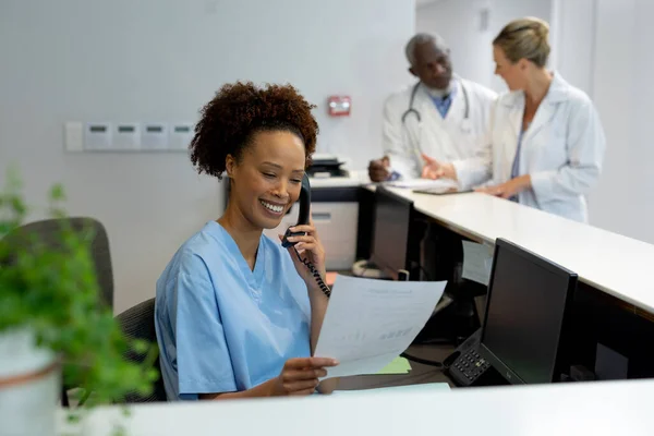 Mixed Race Female Doctor Desk Hospital Reception Talking Phone Holding — Stock Photo, Image
