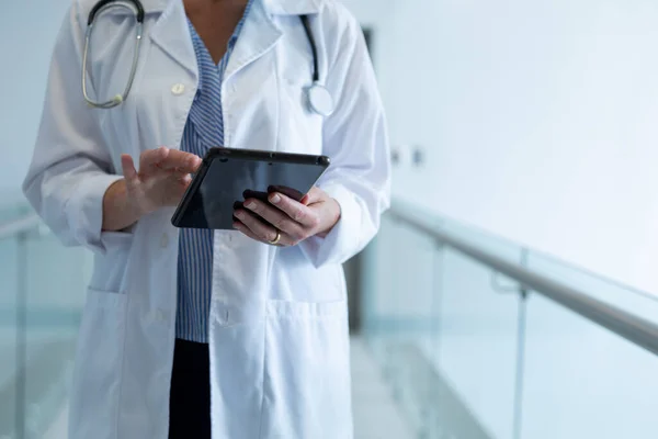 Midsektion Kvinnlig Läkare Som Står Sjukhuskorridoren Med Hjälp Digitala Tabletter — Stockfoto