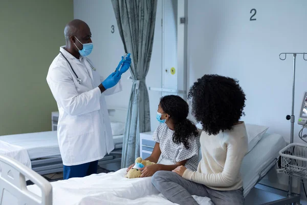 男性医師は 病院のベッドで母親と病気の女の子のために すべての顔のマスクでCovidワクチンを準備する コロナウイルスにおける医療 医療サービス Covid 19パンデミック — ストック写真