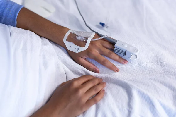 指先パルス酸素濃度計とIvチューブを装着した病院のベッドでの女性患者の手 医療サービス — ストック写真