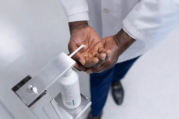 Midsection Doutor Masculino Casaco Branco Que Desinfecta Mãos Corredor Hospital — Fotografia de Stock