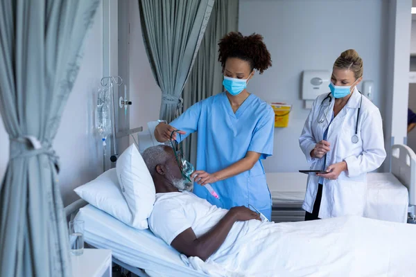 混合种族的女医生戴着面罩 给男性患者戴上氧气面罩通风机 Coronavirus Covid大流行病期间的医疗 保健和保健服务 — 图库照片