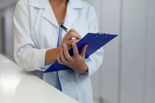 Мидсекция Женщины Врача Стоящей Больничном Коридоре Заполняет Медицинскую Карту Медицина — стоковое фото