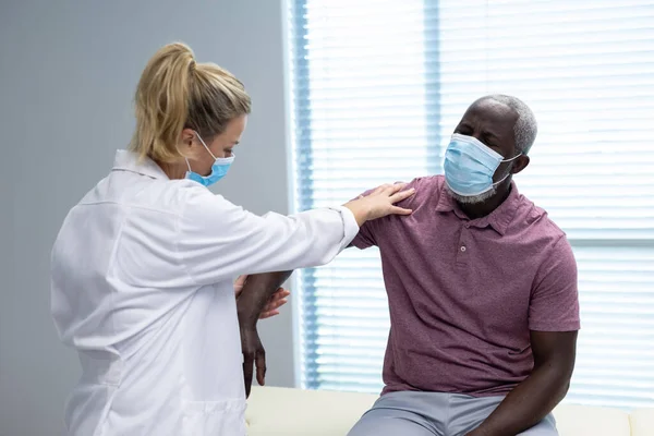 Physiothérapeute Caucasienne Portant Masque Étirant Bras Patient Afro Américain Médicaments — Photo