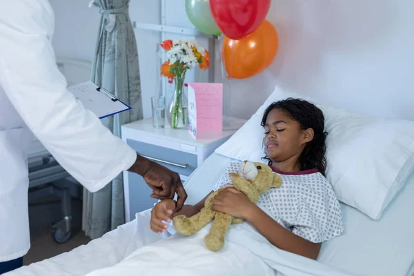 Médico Afroamericano Tomando Pulso Niña Enferma Raza Mixta Dormida Cama —  Fotos de Stock