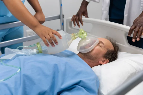 Diversos Médicos Masculinos Femininos Colocando Máscara Oxigênio Paciente Deitado Cama — Fotografia de Stock