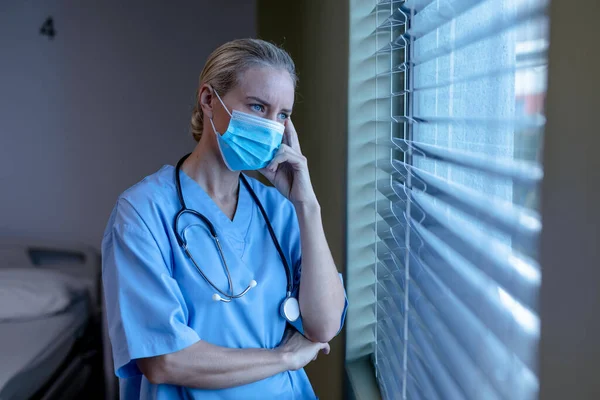 Bezorgde Blanke Vrouwelijke Arts Het Ziekenhuis Draagt Gezichtsmasker Scrubs Kijken — Stockfoto