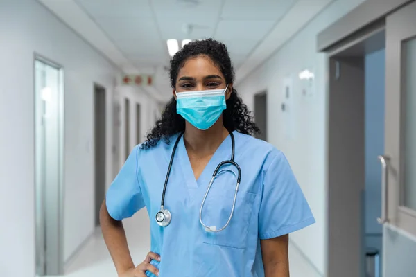 Hastane Koridorunda Duran Yüz Maskesi Takan Melez Kadın Doktor Portresi — Stok fotoğraf