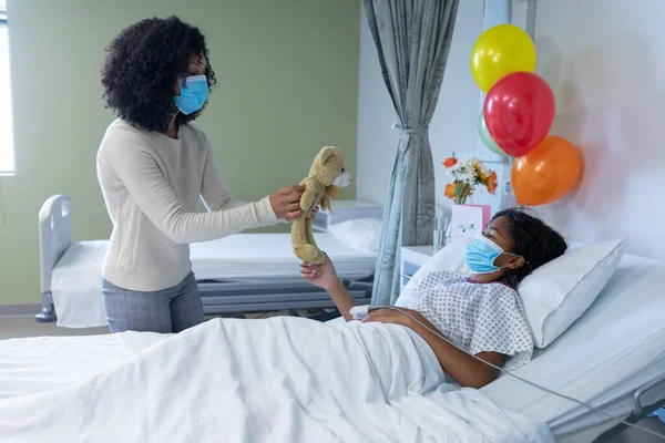 Mixed Race Mother Sick Daughter Face Masks Hospital Playing Teddy — Stock Photo, Image