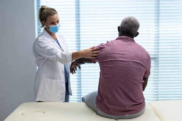 치료사가 아프리카 미국인 환자의 마스크 스트레칭 있어요 코로나 바이러스가 맹위를 — 스톡 사진