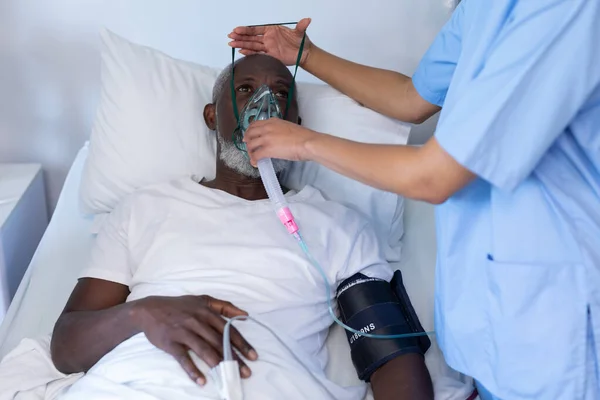 Vrouwelijke Dokter Zet Zuurstofmasker Ventilator Afro Amerikaanse Mannelijke Patiënt Liggend — Stockfoto