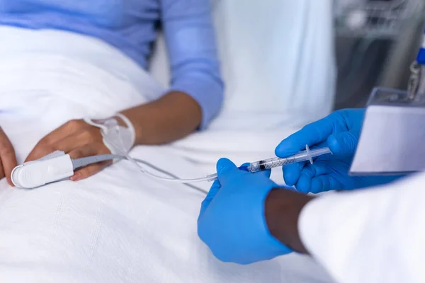 病院のベッドで女性患者に4注射を与える男性医師の中央部 コロナウイルスにおける医療 医療サービス Covid 19パンデミック — ストック写真
