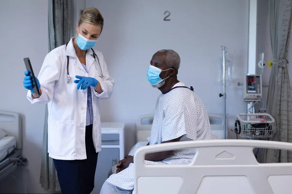 Diverso Médico Femenino Paciente Masculino Con Máscaras Mirando Tableta Habitación —  Fotos de Stock